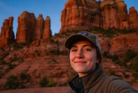 After: the same red rock sunset selfie with only the woman in the cap