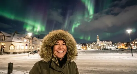 After: the same northern lights selfie with only the woman in the fur-trimmed hood