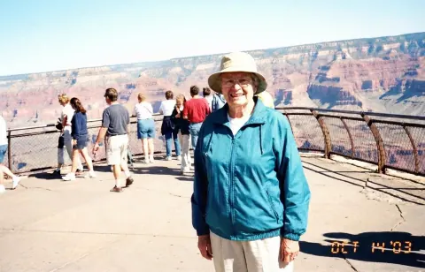 After: the same canyon overlook photo with only the woman in the teal jacket