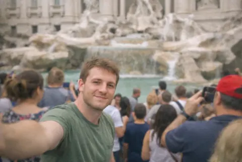 After: the same fountain selfie with only the man in the green T-shirt