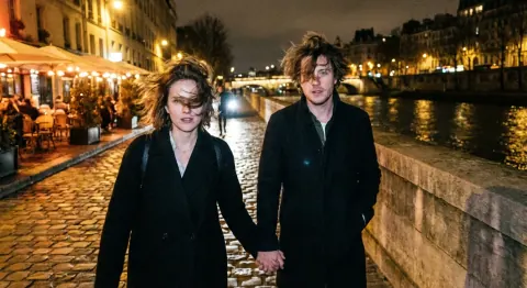Before: a couple holding hands on a cobblestone riverside street at night